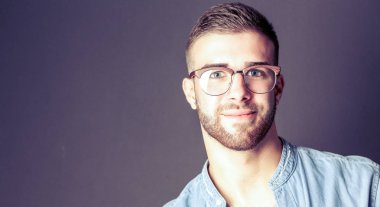 Mutlu bir casual adam ayakta karanlık bir arka plan üzerinde izole portresi