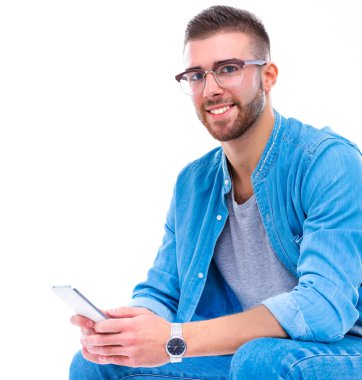 Sandalyede oturan ve cep telefonuyla genç adam