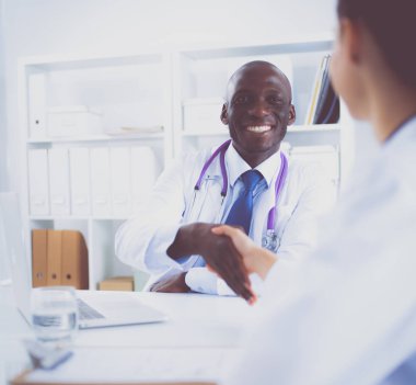 Ofiste tokalaşırken gülümseyen iki genç doktor.