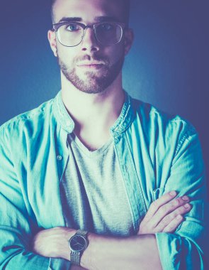 Mutlu bir casual adam ayakta karanlık bir arka plan üzerinde izole portresi