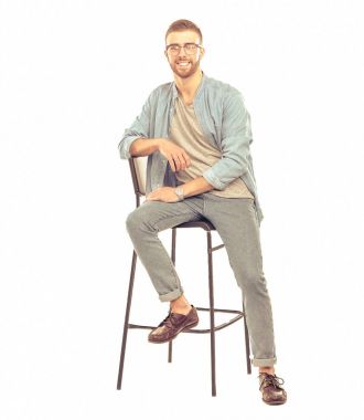 Beyaz arka plan üzerinde izole sandalye üzerinde oturan genç adam