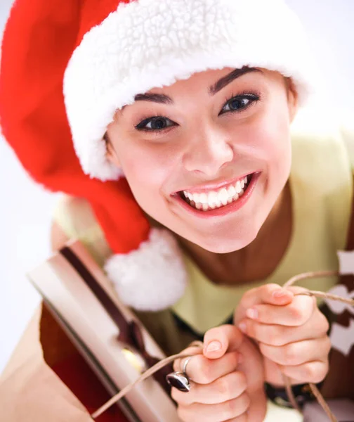 Smiling woman in santa hat with many gift boxes on white background — Stock Photo, Image