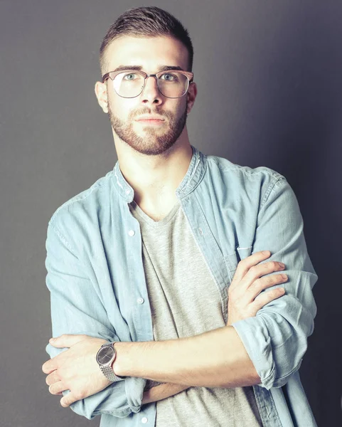 Portrait of a happy casual man standing isolated on a dark background — Stock Photo, Image