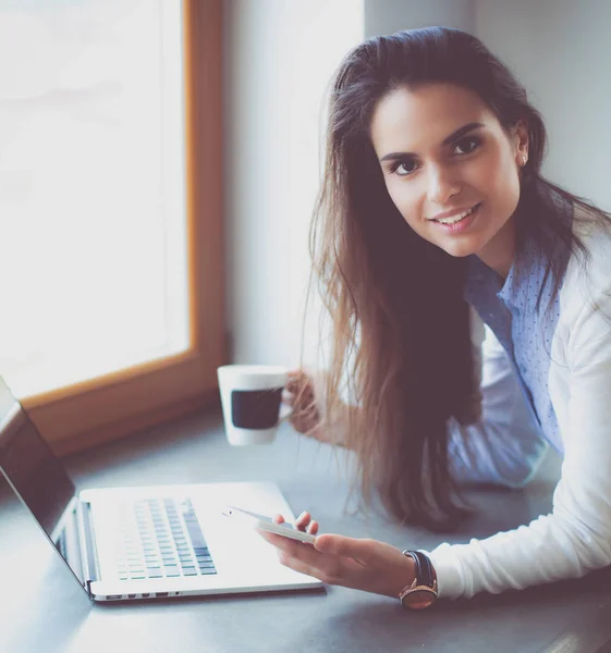 Young female standing near desk with laptop — Stock Photo, Image