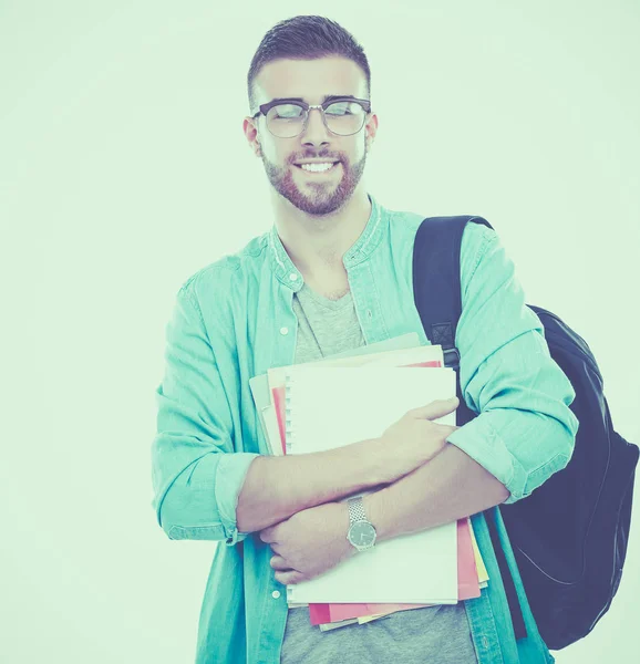 Un estudiante masculino con una bolsa de la escuela sosteniendo libros aislados sobre fondo blanco —  Fotos de Stock