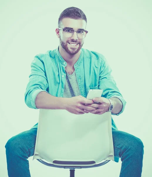 Jeune homme assis sur la chaise isolé sur fond blanc — Photo