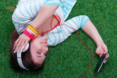 Yeşil çimlerde oturan genç bir kadın. Portreit genç bayan