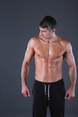 kaslı adam. Kaslı adam kas gösterilen gri arka plan üzerinde. Fitness Eğitmeni. Fitness profesyonel. Egzersiz. Mens fitness.