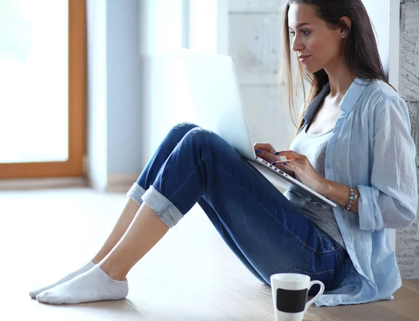 Mooie jongedame thuis zittend op de vloer met laptop. Mooie jongedame. — Stockfoto