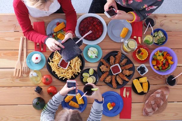 Вид сверху на группу людей, обедающих вместе за деревянным столом. Еда на столе. Люди едят фаст-фуд. — стоковое фото