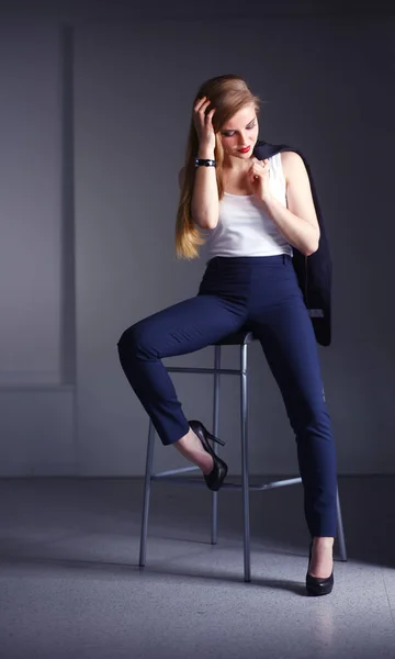 Una joven sentada en una silla. Mujer joven — Foto de Stock