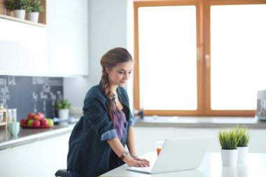 Güzel, genç, gülümseyen bayan doktor masada oturuyor ve yazıyor..