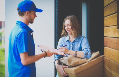 Mavi üniformalı gülümseyen kurye servis konseptine paket kutusu teslim eden teslimatçı. Mavi üniformalı gülümseyen teslimatçı.
