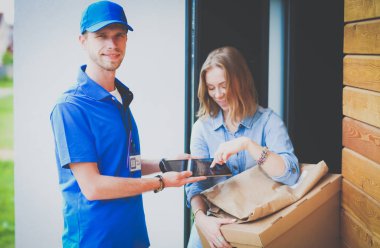 Mavi üniformalı gülümseyen kurye servis konseptine paket kutusu teslim eden teslimatçı. Mavi üniformalı gülümseyen teslimatçı.