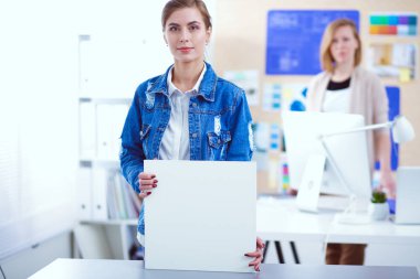 Masanın yanında duran iki genç kadın enstrüman, plan ve dizüstü bilgisayarla.