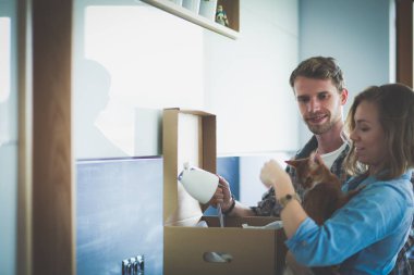 Genç bir çift yeni evde büyük karton kutu taşıyan. Ev taşıma. Genç Çift