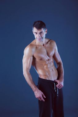 kaslı adam. Kaslı adam kas gösterilen gri arka plan üzerinde. Fitness Eğitmeni. Fitness profesyonel. Egzersiz. Mens fitness.