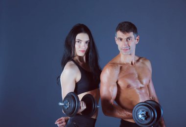 Atletik erkek ve kadın salak-bells ile. Kişisel fitness eğitmeni. Kişisel eğitim. Ağırlık çalışması. Egzersiz.