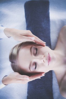 Masaj masasında uzanmış gözleri kapalı rahatlayan genç bir kadın. - Kadın. Spa salonu