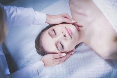 Masaj masasında uzanmış gözleri kapalı rahatlayan genç bir kadın. - Kadın. Spa salonu