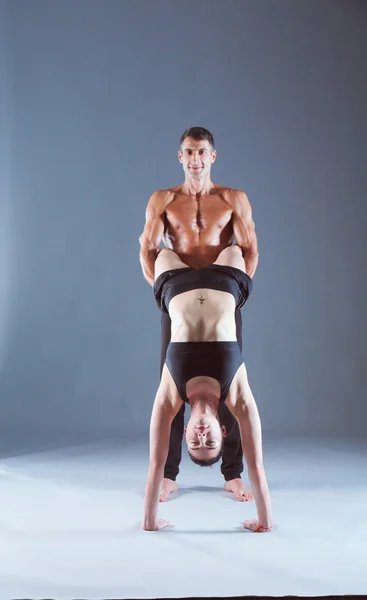 Young couple practicing acro yoga on mat in studio together. Acroyoga. Couple yoga. Partner yoga. — Stock Photo, Image