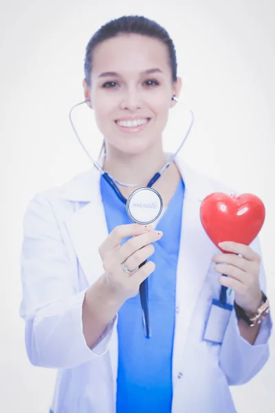 Médecin féminin positif debout avec stéthoscope et symbole du cœur rouge isolé. Femme médecin — Photo