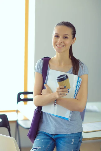 Retrato de una joven estudiante sosteniendo libros de ejercicios. Estudiante mujer — Foto de Stock