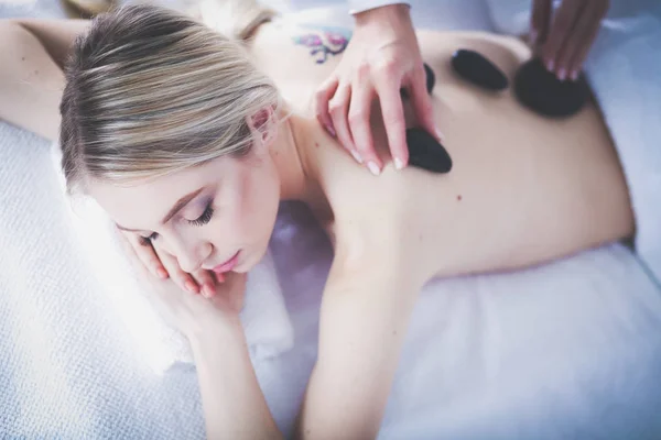 Ung kvinna liggande på ett massagebord, avslappnande med slutna ögon. Kvinnan. Spasalong — Stockfoto