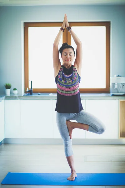 Retrato de una mujer sonriente de yoga sentada en la esterilla de yoga después del entrenamiento en el estudio de yoga. Yoga. Mujer. . — Foto de Stock