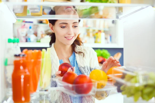 Portret kobiety stojącej w pobliżu otwartej lodówki pełnej zdrowej żywności, warzyw i owoców. Portret kobiety — Zdjęcie stockowe