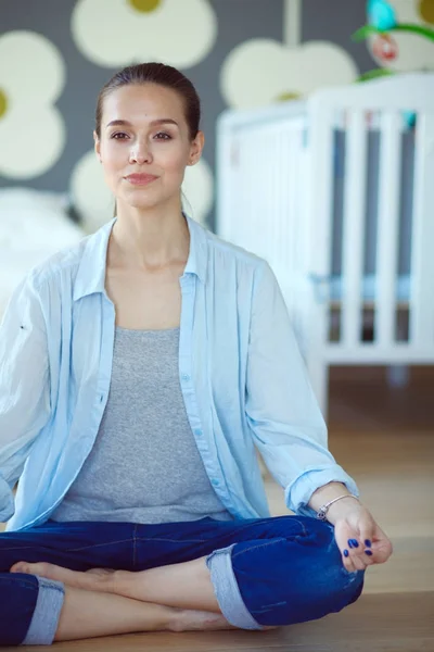 Young woman doing yoga at home in the lotus position. Young woman doing yoga. — Stock Photo, Image