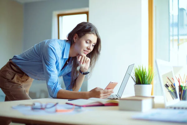 Ung kvinna som sitter vid ett skrivbord. Affärskvinna. Jag ritar. Studerande. Arbetsplats. Skrivbord. — Stockfoto