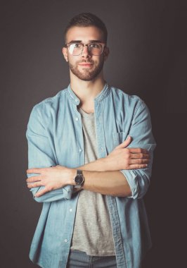 Mutlu bir casual adam ayakta karanlık bir arka plan üzerinde izole portresi. Yakışıklı erkek poz.