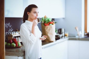 Giderleri planlama ve mutfağını faturalarında ödeme genç kadın.