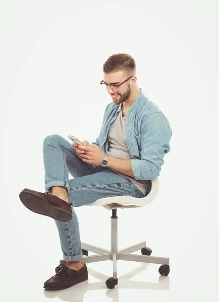 Ung man sitter på stol och med hjälp av mobiltelefon. Startupper. Ung entreprenör. — Stockfoto