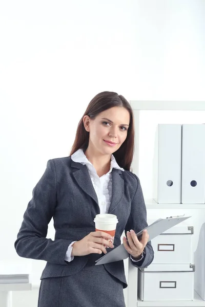 Donna d'affari in piedi contro la finestra dell'ufficio che tiene il computer portatile. Imprenditrice — Foto Stock