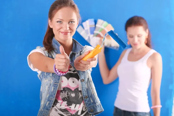 Dos hermosas mujeres jóvenes pintando paredes. Dos Hermosa joven mujer —  Fotos de Stock