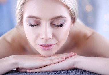 Masaj masasında uzanmış gözleri kapalı rahatlayan genç bir kadın. - Kadın. Spa salonu