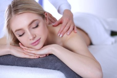 Masaj masasında uzanmış gözleri kapalı rahatlayan genç bir kadın. - Kadın. Spa salonu