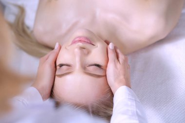 Masaj masasında uzanmış gözleri kapalı rahatlayan genç bir kadın. - Kadın. Spa salonu