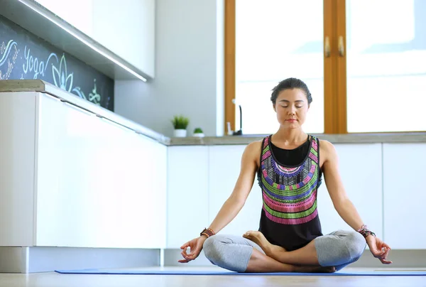 Mujer joven haciendo yoga en casa en la posición de loto. Yoga. Una mujer. Estilo de vida — Foto de Stock