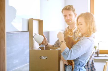 Genç bir çift yeni evde büyük karton kutu taşıyan. Ev taşıma. Genç Çift