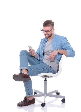 Sandalyede oturan ve cep telefonuyla genç adam. Startupper. Genç girişimci.