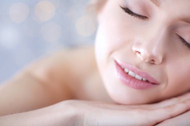 Masaj masasında uzanmış gözleri kapalı rahatlayan genç bir kadın. - Kadın. Spa salonu