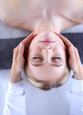 Masaj masasında uzanmış gözleri kapalı rahatlayan genç bir kadın. - Kadın. Spa salonu