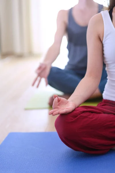 Joven pareja sana en posición de yoga sobre fondo blanco — Foto de Stock