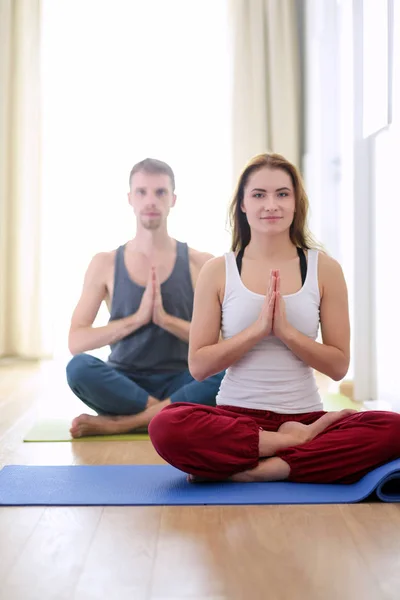 Joven pareja sana en posición de yoga sobre fondo blanco —  Fotos de Stock