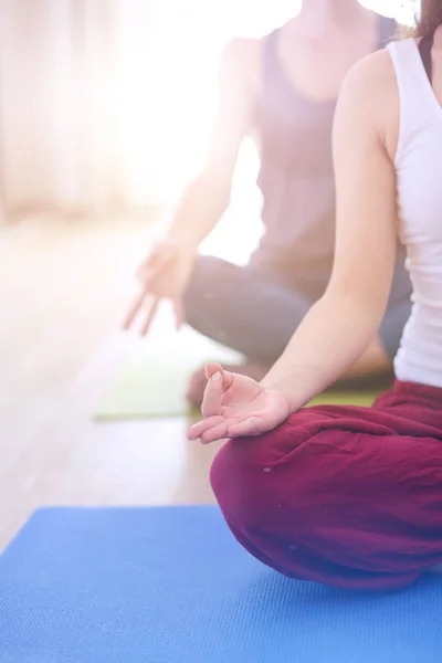 Joven pareja sana en posición de yoga sobre fondo blanco — Foto de Stock