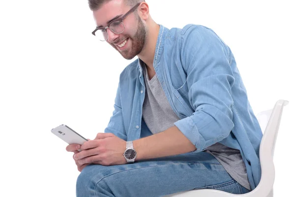 Junger Mann auf Stuhl sitzend und mit Handy. Startupper. Jungunternehmer. — Stockfoto