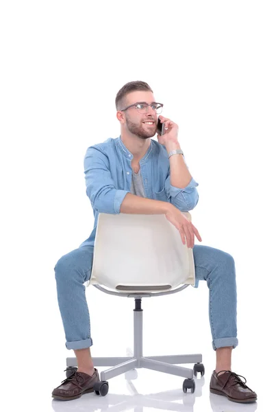 Jeune homme assis sur une chaise et utilisant un téléphone portable. Démarreur. Jeune entrepreneur . — Photo